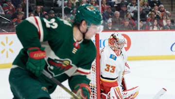 ST PAUL, MINNESOTA - JANUARY 05: David Rittich #33 of the Calgary Flames looks on as Kevin Fiala #22 of the Minnesota Wild controls the puck during the game at Xcel Energy Center on January 5, 2020 in St Paul, Minnesota. The Flames defeated the Wild 5-4 in a shootout. (Photo by Hannah Foslien/Getty Images)