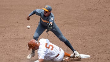 Jun 22, 2021; Omaha, Nebraska, USA; Tennessee Volunteers infielder Liam Spence (4) attempts to tag out Texas Longhorns outfielder Mike Antico (5) on a steal attempt in the third inning at TD Ameritrade Park. Mandatory Credit: Steven Branscombe-USA TODAY Sports