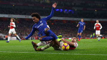 LONDON, ENGLAND - JANUARY 19: Willian of Chelsea is tackled by Sokratis Papastathopoulos of Arsenal during the Premier League match between Arsenal FC and Chelsea FC at Emirates Stadium on January 19, 2019 in London, United Kingdom. (Photo by Catherine Ivill/Getty Images)