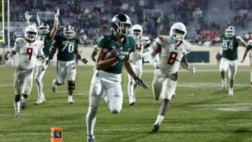 EAST LANSING, MI - NOVEMBER 24: Wide receiver Cody White #7 of the Michigan State Spartans is pursued by defensive back Saquan Hampton #9 of the Rutgers Scarlet Knights and linebacker Tyshon Fogg #8 of the Rutgers Scarlet Knights on a 22-yard touchdown run during the fourth quarter at Spartan Stadium on November 24, 2018 in East Lansing, Michigan. Michigan State defeated Rutgers 14-10. (Photo by Duane Burleson/Getty Images)
