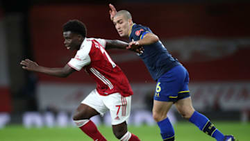 LONDON, ENGLAND - DECEMBER 16: Bukayo Saka of Arsenal gets away from Oriol Romeu of Southampton during the Premier League match between Arsenal and Southampton at Emirates Stadium on December 16, 2020 in London, England. The match will be played without fans, behind closed doors as a Covid-19 precaution. (Photo by Peter Cziborra - Pool/Getty Images)