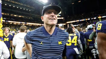 Michigan head coach Jim Harbaugh walks around the field to celebrates with coaches and players after winning the Big Ten Championship at Lucas Oil Stadium in Indianapolis, Ind., on Saturday, Dec. 3, 2022.