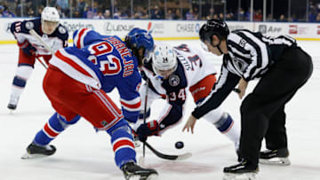 NEW YORK, NEW YORK - OCTOBER 29: Linesman Libor Suchanek #60 drops the puck as Mika Zibanejad #93 of the New York Rangers and Cole Sillinger #34 of the Columbus Blue Jackets face off during the first period at Madison Square Garden on October 29, 2021 in New York City. (Photo by Sarah Stier/Getty Images)