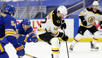 Apr 20, 2021; Buffalo, New York, USA; Buffalo Sabres center Arttu Ruotsalainen (25) tries to get the puck from Boston Bruins right wing Craig Smith (12) as he skates during the third period at KeyBank Center. Mandatory Credit: Timothy T. Ludwig-USA TODAY Sports