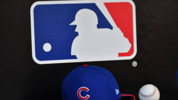 MIAMI, FL - APRIL 01: A detailed view of the New Era ball cap and MLB logo in the dugout of the Chicago Cubs against the Miami Marlins at Marlins Park on April 1, 2018 in Miami, Florida. (Photo by B51/Mark Brown/Getty Images) *** Local Caption ***