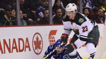 Nov 29, 2016; Vancouver, British Columbia, CAN; Minnesota Wild defenseman Gustav Olofsson (23) picks up the puck from Vancouver Canucks forward Alexandre Burrows (14) during the first period at Rogers Arena. Mandatory Credit: Anne-Marie Sorvin-USA TODAY Sports