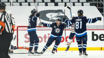 May 24, 2021; Winnipeg, Manitoba, CAN; Winnipeg Jets forward Mark Scheifele (55) is congratulated by his team mates on his goal against the Edmonton Oilers during the first period in game four of the first round of the 2021 Stanley Cup Playoffs at Bell MTS Place. Mandatory Credit: Terrence Lee-USA TODAY Sports