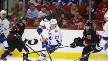 Jan 27, 2015; Raleigh, NC, USA; Tampa Bay Lightning forward Jonathan Drouin (27) skates with puck against Carolina Hurricanes forward Riley Nash (20) during the first period at PNC Arena. Mandatory Credit: James Guillory-USA TODAY Sports