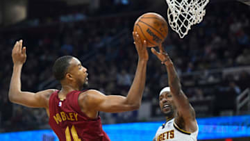Feb 23, 2023; Cleveland, Ohio, USA; Denver Nuggets guard Kentavious Caldwell-Pope (5) throws a pass against Cleveland Cavaliers forward Evan Mobley (4) in the second quarter at Rocket Mortgage FieldHouse. Mandatory Credit: David Richard-USA TODAY Sports