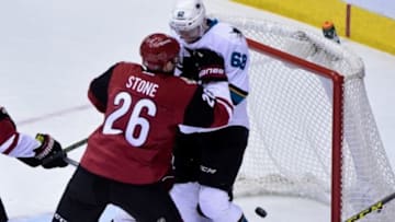 Jan 21, 2016; Glendale, AZ, USA; San Jose Sharks center Chris Tierney (not pictured) scores a goal as Arizona Coyotes defenseman Michael Stone (26) shoves right wing Melker Karlsson (68) into the net during the first period at Gila River Arena. Mandatory Credit: Matt Kartozian-USA TODAY Sports