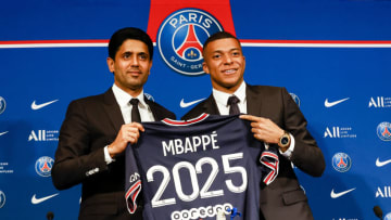 PARIS, FRANCE - MAY 23: Nasser Al-Khelaifi talks PSG president (L) and Kylian Mbappe (R) poses for photos with 2025 PSG t-shirt indicates the new contract of Mbappe during the Press Conference of Paris Saint-Germain at Parc des Princes on May 23, 2022 in Paris, France. (Photo by Antonio Borga/Eurasia Sport Images/Getty Images)