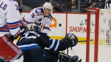 Dec 8, 2016; Winnipeg, Manitoba, CAN; New York Rangers defenseman Brady Skjei (76) looks to control the puck as Winnipeg Jets goalie Michael Hutchinson (34) prepares to make a save during the third period at MTS Centre. Rangers win 2-1. Mandatory Credit: Bruce Fedyck-USA TODAY Sports