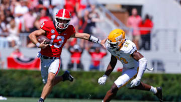 ATHENS, GA - SEPTEMBER 24: Stetson Bennett #13 of the Georgia Bulldogs stiff arms Marvin Pierre #33 of the Kent State Golden Flashes in the first half at Sanford Stadium on September 24, 2022 in Athens, Georgia. (Photo by Todd Kirkland/Getty Images)