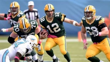 Oct 12, 2014; Miami Gardens, FL, USA; Green Bay Packers quarterback Aaron Rodgers (12) scrambles for a first down against the Miami Dolphins in the first quarter of the game at Sun Life Stadium. Mandatory Credit: Brad Barr-USA TODAY Sports