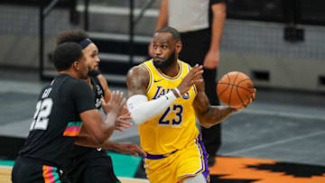 Jan 1, 2021; San Antonio, Texas, USA; Los Angeles Lakers forward LeBron James (23) drives around San Antonio Spurs forward Rudy Gay (22) and guard Derrick White (middle) in the second half at the AT&T Center. Mandatory Credit: Daniel Dunn-USA TODAY Sports
