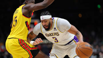 ATLANTA, GEORGIA - JANUARY 30: Anthony Davis #3 of the Los Angeles Lakers turns over the ball as he is charged with traveling while driving into Clint Capela #15 of the Atlanta Hawks during the first half at State Farm Arena on January 30, 2022 in Atlanta, Georgia. NOTE TO USER: User expressly acknowledges and agrees that, by downloading and or using this photograph, User is consenting to the terms and conditions of the Getty Images License Agreement. (Photo by Kevin C. Cox/Getty Images)