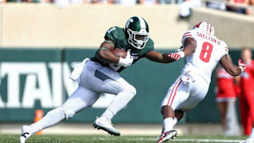 Sep 24, 2016; East Lansing, MI, USA; Michigan State Spartans running back LJ Scott (3) runs the ball against Wisconsin Badgers cornerback Sojourn Shelton (8) during the first half of a game at Spartan Stadium. Mandatory Credit: Mike Carter-USA TODAY Sports