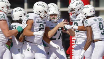 BLOOMINGTON, IN - OCTOBER 16: Members of the Michigan State Spartans defense celebrate with Cal Haladay #27 of the Michigan State Spartans after an interception returned for a touchdown against the Indiana Hoosiers at Indiana University on October 16, 2021 in Bloomington, Indiana. (Photo by Michael Hickey/Getty Images)