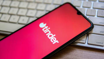 SPAIN - 2022/04/25: In this photo illustration, a Tinder logo seen displayed on a smartphone placed on top of a computer keyboard. (Photo Illustration by Thiago Prudencio/SOPA Images/LightRocket via Getty Images)