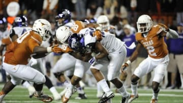 Nov 27, 2014; Austin, TX, USA; TCU Horned Frogs running back Aaron Green (22) is tackled by Texas Longhorns defensive end Cedric Reed (88) and defensive tackle Malcom Brown (90) during the game at Darrell K Royal-Texas Memorial Stadium. Mandatory Credit: Brendan Maloney-USA TODAY Sports