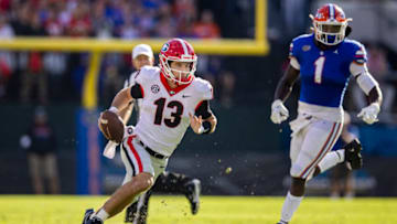 JACKSONVILLE, FLORIDA - OCTOBER 30: Stetson Bennett #13 of the Georgia Bulldogs runs for yardage during the second half of a game against the Florida Gators at TIAA Bank Field on October 30, 2021 in Jacksonville, Florida. (Photo by James Gilbert/Getty Images)