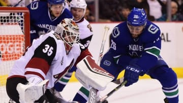 Oct 3, 2016; Vancouver, British Columbia, CAN; Vancouver Canucks forward Emerson Etem (26) and Arizona Coyotes goaltender Louis Domingue (35) reach for the puck during a preseason hockey game at Rogers Arena. Mandatory Credit: Anne-Marie Sorvin-USA TODAY Sports