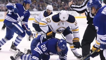 Mar 7, 2016; Toronto, Ontario, CAN; Toronto Maple Leafs right wing Ben Smith (26) falls near the puck after the face off as Buffalo Sabres left wing Marcus Foligno (82) battles for the puck at Air Canada Centre. The Sabres beat the Maple Leafs 4-3 in a shootout. Mandatory Credit: Tom Szczerbowski-USA TODAY Sports