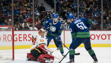 Feb 8, 2020; Vancouver, British Columbia, CAN; Calgary Flames goalie David Rittich (33) makes a save as Vancouver Canucks forward Elias Pettersson (40) and forward Bo Horvat (53) look for the rebound during the third period at Rogers Arena. Calgary won 6-2. Mandatory Credit: Bob Frid-USA TODAY Sports