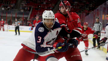 RALEIGH, NC - NOVEMBER 17: Clark Bishop #64 of the Carolina Hurricanes and Seth Jones #3 of the Columbus Blue Jackets battle for position during an NHL game on November 17, 2018 at PNC Arena in Raleigh, North Carolina. (Photo by Gregg Forwerck/NHLI via Getty Images)
