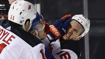 NEW YORK, NY - JANUARY 07: Anders Lee #27 of the New York Islanders gets the glove up on Steven Santini #16 of the New Jersey Devils at the Barclays Center on January 7, 2018 in the Brooklyn borough of New York City. The Islanders defeated the Devils 5-4 in the shootout. (Photo by Bruce Bennett/Getty Images)