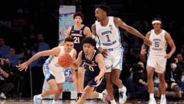 Mar 10, 2022; Brooklyn, NY, USA; Virginia Cavaliers guard Kihei Clark (0) brings the ball up court against North Carolina Tar Heels guard Leaky Black (1) and forward Justin McKoy (22) during the second half at Barclays Center. Mandatory Credit: Brad Penner-USA TODAY Sports