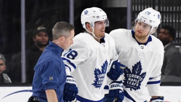LAS VEGAS, NEVADA - FEBRUARY 14: Andreas Johnsson #18 of the Toronto Maple Leafs is helped off the ice by a trainer and teammate William Nylander #29 after Johnsson and Brayden McNabb (not pictured) #3 of the Vegas Golden Knights collided in the second period of their game at T-Mobile Arena on February 14, 2019 in Las Vegas, Nevada. The Maple Leafs defeated the Golden Knights 6-3. (Photo by Ethan Miller/Getty Images)