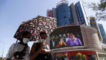 ADDIS ABABA, ETHIOPIA - JANUARY 27: Ethiopian women wearing protective face masks and using an umbrella to protect themselves from the sun walk at a street amid coronavirus (Covid-19) pandemic in Addis Ababa, Ethiopia on January 27, 2021. (Photo by Minasse Wondimu Hailu/Anadolu Agency via Getty Images)
