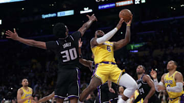 LOS ANGELES, CALIFORNIA - JANUARY 04: LeBron James #6 of the Los Angeles Lakers scores as he is fouled in front of Damian Jones #30 of the Sacramento Kings during a 122-114 Los Angeles Lakers win at Staples Center on January 04, 2022 in Los Angeles, California. (Photo by Harry How/Getty Images) NOTE TO USER: User expressly acknowledges and agrees that, by downloading and/or using this Photograph, user is consenting to the terms and conditions of the Getty Images License Agreement. Mandatory Copyright Notice: Copyright 2022 NBAE