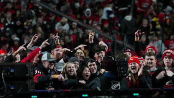 Feb 18, 2023; Raleigh, North Carolina, USA; Carolina Hurricanes fans cheer in the stands in front of the camera in the third period against the Washington Capitals during the 2023 Stadium Series ice hockey game at Carter-Finley Stadium. Mandatory Credit: James Guillory-USA TODAY Sports