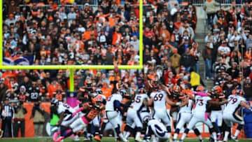 Oct 18, 2015; Cleveland, OH, USA; Denver Broncos kicker Brandon McManus (8) kicks the game-winning field goal out of the hold of punter Britton Colquitt (4) in overtime against the Cleveland Browns at FirstEnergy Stadium. Denver defeated Cleveland 26-23. Mandatory Credit: James Lang-USA TODAY Sports