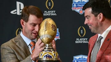 Clemson Head Coach Dabo Swinney get ready to pose with Ohio State Head Coach Ryan Day during the Fiesta Bowl trophy at the coaches press conference in Scottsdale, Arizona Friday December 27, 2019.Clemson Fans Fiesta Bowl Coaches Conference