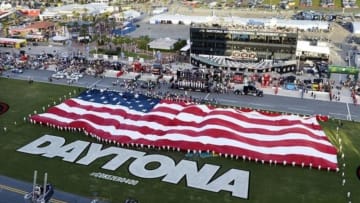 Jul 6, 2013; Daytona Beach, FL, USA; NASCAR Sprint Cup Series fans listen to the National Anthem as the U.S. flag is unveiled prior to the start of the Coke Zero 400 at Daytona International Speedway. Mandatory Credit: John David Mercer-USA TODAY Sports