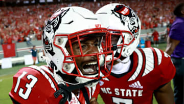 RALEIGH, NORTH CAROLINA - SEPTEMBER 25: Tyler Baker-Williams #13 of the North Carolina State Wolfpack celebrates after his game-winning pass breakup against the Clemson Tigers during the second overtime of their game at Carter-Finley Stadium on September 25, 2021 in Raleigh, North Carolina. North Carolina State won 27-21 in double overtime. (Photo by Grant Halverson/Getty Images)