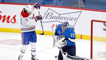 Mar 17, 2021; Winnipeg, Manitoba, CAN; Winnipeg Jets goaltender Connor Hellebuyck (37) blocks a shot by Montreal Canadiens center Tyler Toffoli (73) in the first period at Bell MTS Place. Mandatory Credit: James Carey Lauder-USA TODAY Sports