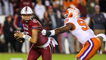 Nov 27, 2021; Columbia, South Carolina, USA; South Carolina Gamecocks quarterback Jason Brown (15) eludes the grasp of Clemson Tigers defensive end Myles Murphy (98) in the first quarter at Williams-Brice Stadium. Mandatory Credit: Jeff Blake-USA TODAY Sports