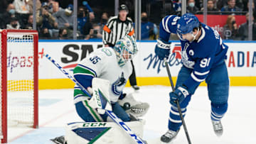Mar 5, 2022; Toronto, Ontario, CAN; Toronto Maple Leafs center John Tavares (91) battles for the puck in front of Vancouver Canucks goaltender Thatcher Demko (35) during the first period at Scotiabank Arena. Mandatory Credit: Nick Turchiaro-USA TODAY Sports