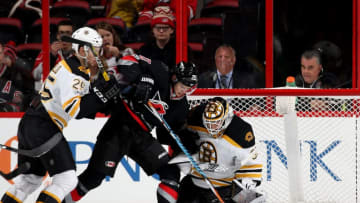 RALEIGH, NC - JANUARY 08: Sebastian Aho #20 of the Carolina Hurricanes looks to jam the puck in the net as Zane McIntrye #31 of the Boston Bruins goes down in the crease and Brandon Carlo #25 defends during an NHL game on January 8, 2017 at PNC Arena in Raleigh, North Carolina. (Photo by Gregg Forwerck/NHLI via Getty Images)