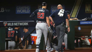 ARLINGTON, TEXAS - OCTOBER 12: Head athletic trainer George Poulis escorts Adam Duvall #23 of the Atlanta Braves off the field after an injury during the second inning in Game One of the National League Championship Series against the Los Angeles Dodgers at Globe Life Field on October 12, 2020 in Arlington, Texas. (Photo by Tom Pennington/Getty Images)