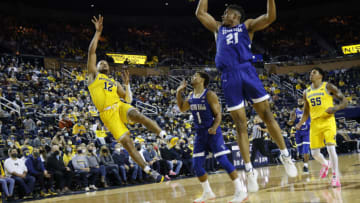 Nov 16, 2021; Ann Arbor, Michigan, USA; Michigan Wolverines guard DeVante' Jones (12) shoots over Seton Hall Pirates guard Bryce Aiken (1) and center Ike Obiagu (21) in the first half at Crisler Center. Mandatory Credit: Rick Osentoski-USA TODAY Sports