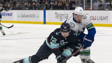 Jan 1, 2022; Seattle, Washington, USA; Seattle Kraken right wing Joonas Donskoi (72) and Vancouver Canucks defenseman Quinn Hughes (43) battle for the puck during the second period at Climate Pledge Arena. Mandatory Credit: Stephen Brashear-USA TODAY Sports
