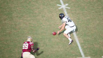 TALLAHASSEE, FL - OCTOBER 15: Punter Dom Maggio #48 of the Wake Forest Demon Deacons fumbles the ball in front of defensive end Brian Burns #99 of the Florida State Seminoles at Doak Campbell Stadium on October 15, 2016 in Tallahassee, Florida. (Photo by Michael Chang/Getty Images)