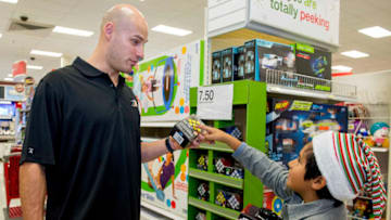 IRVINE, CA - DECEMBER 07: Ducks team Captain Ryan Getzlaf, left, helps Diego Soto, 9, of The Wooden Floor, an arts-based youth development nonprofit in Santa Ana, decide on a toy during a shopping spree at Target at the Irvine Spectrum.///ADDITIONAL INFORMATION: i.1207.skating ?ê 12/7/15 ?ê LEONARD ORTIZ, ORANGE COUNTY REGISTER - _DSC5201.NEF - Members of the Anaheim Ducks will go on a shopping spree at Target with 15 low-income youth currently enrolled at The Wooden Floor, an arts-based youth development nonprofit in Santa Ana, CA. The kids will then go ice skating with the players at the Irvine Spectrum's Ice Rink. (Photo by Leonard Ortiz/Digital First Media/Orange County Register via Getty Images)