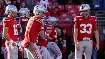 Nov 18, 2023; Columbus, Ohio, USA; Ohio State Buckeyes quarterback Devin Brown (33) and quarterback Lincoln Kienholz (12) watch as quarterback Kyle McCord (6) warms up prior to the NCAA football game against the Minnesota Golden Gophers at Ohio Stadium.