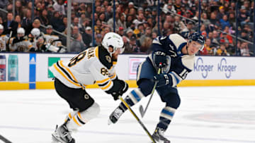 Oct 28, 2022; Columbus, Ohio, USA; Boston Bruins right wing David Pastrnak (88) defends against Columbus Blue Jackets defenseman Gavin Bayreuther (15) during the second period at Nationwide Arena. Mandatory Credit: Russell LaBounty-USA TODAY Sports